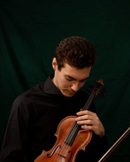 studio portrait photography of musician, violinist holding violin with dark green background 