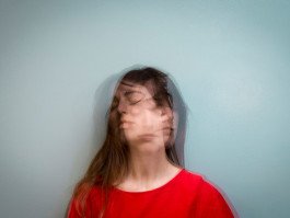 portrait of young woman wearing red blouse with long exposure, light blue background 