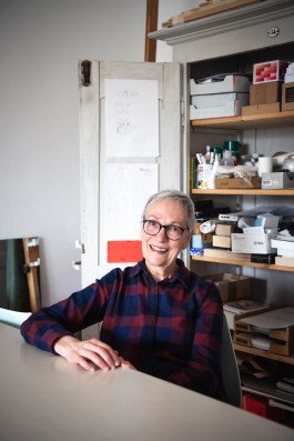 portrait photography of woman artist in front of tools cabinet 