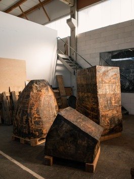 Reportage Fotografie Beispiel, drei grosse geometrische Holzskulpturen in einem Atelier. 