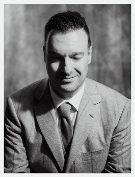 Schwarz-Weiß-Porträt eines Künstler mit geschlossene Augen in einem klassischen Anzug. 